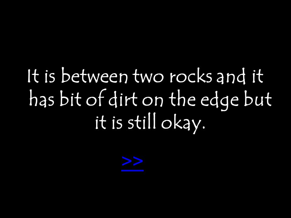It is between two rocks and it has bit of dirt on the edge but it is still okay. >>