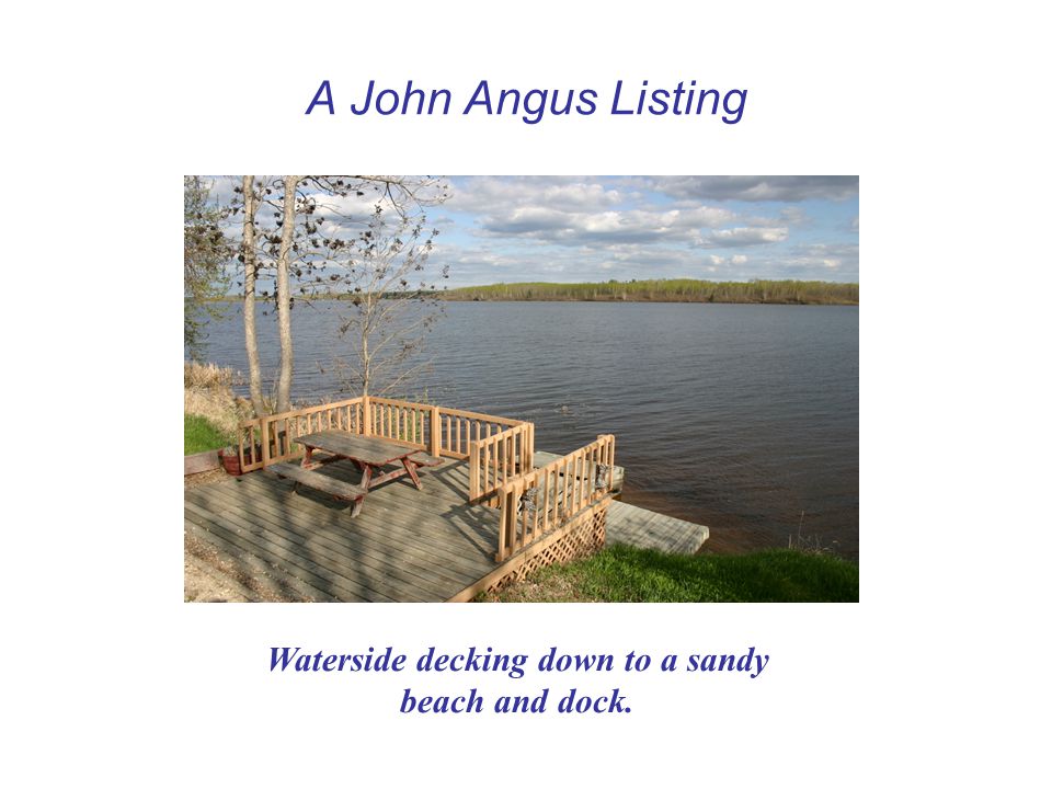A John Angus Listing Waterside decking down to a sandy beach and dock.