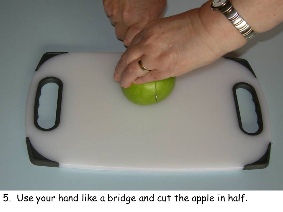 5. Use your hand like a bridge and cut the apple in half.