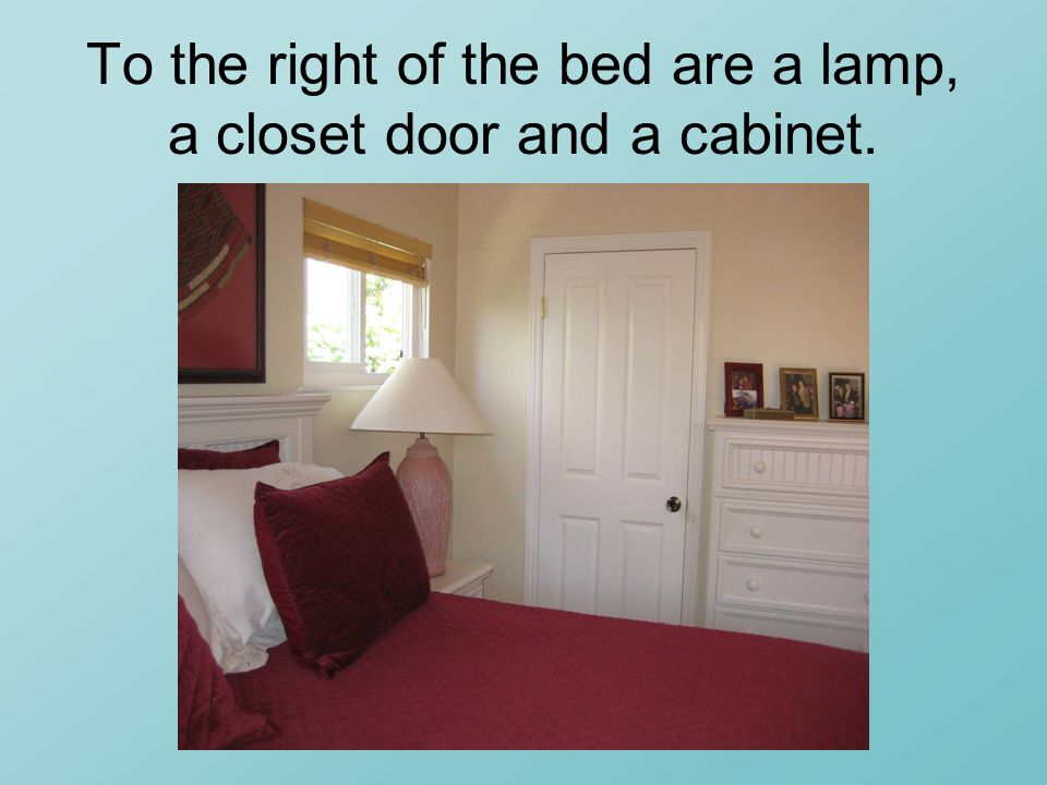 To the right of the bed are a lamp, a closet door and a cabinet.