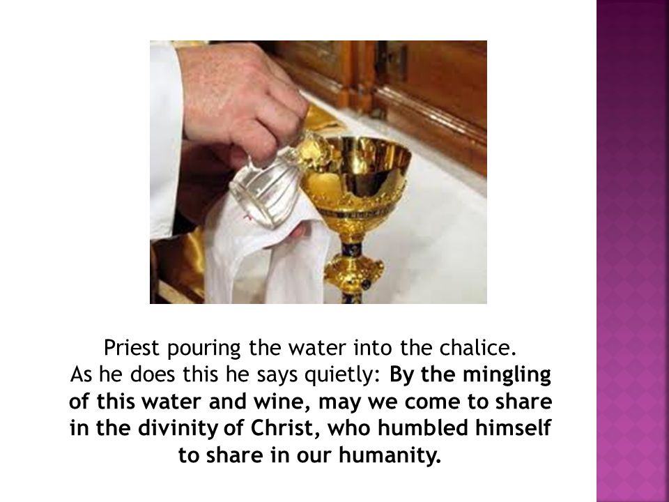 Priest pouring the water into the chalice.