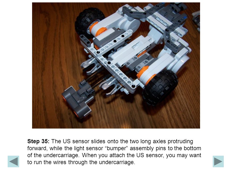 Step 35: The US sensor slides onto the two long axles protruding forward, while the light sensor bumper assembly pins to the bottom of the undercarriage.