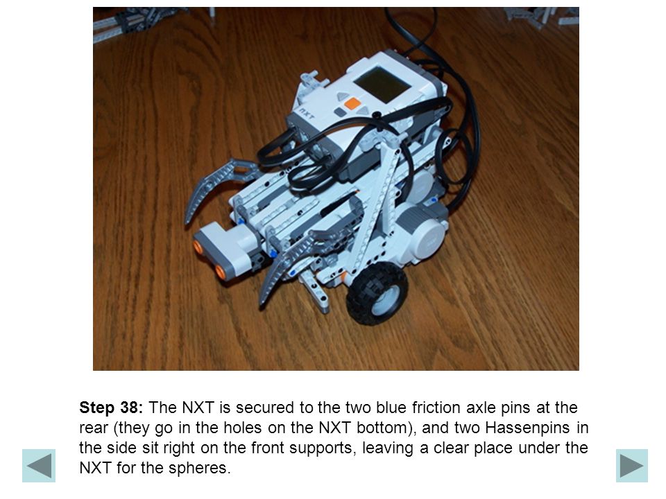Step 38: The NXT is secured to the two blue friction axle pins at the rear (they go in the holes on the NXT bottom), and two Hassenpins in the side sit right on the front supports, leaving a clear place under the NXT for the spheres.