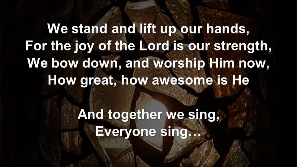 We stand and lift up our hands, For the joy of the Lord is our strength, We bow down, and worship Him now, How great, how awesome is He And together we sing, Everyone sing…