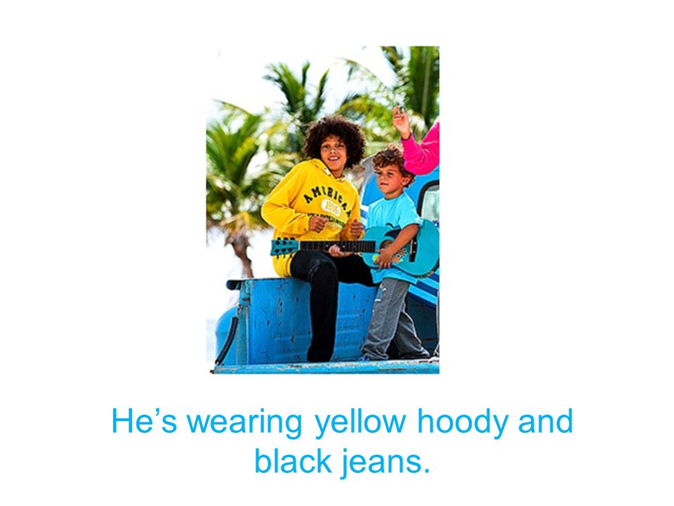 He’s wearing yellow hoody and black jeans.