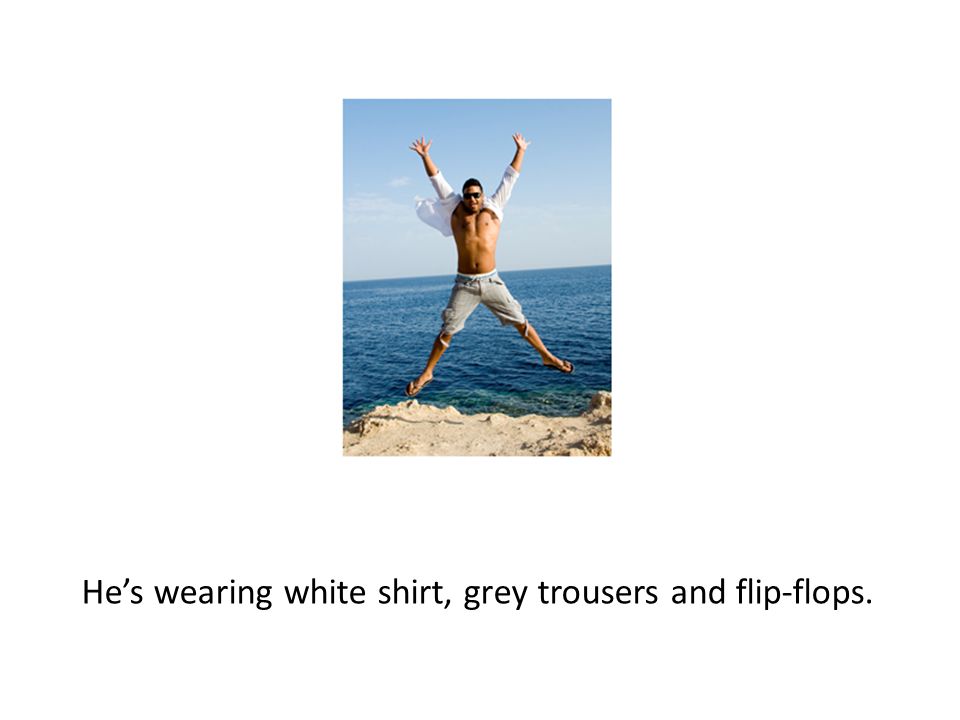 He’s wearing white shirt, grey trousers and flip-flops.