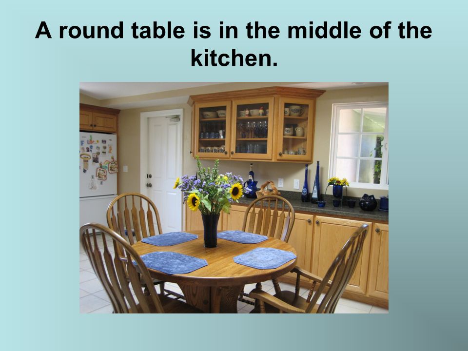 A round table is in the middle of the kitchen.
