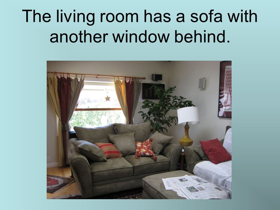 The living room has a sofa with another window behind.