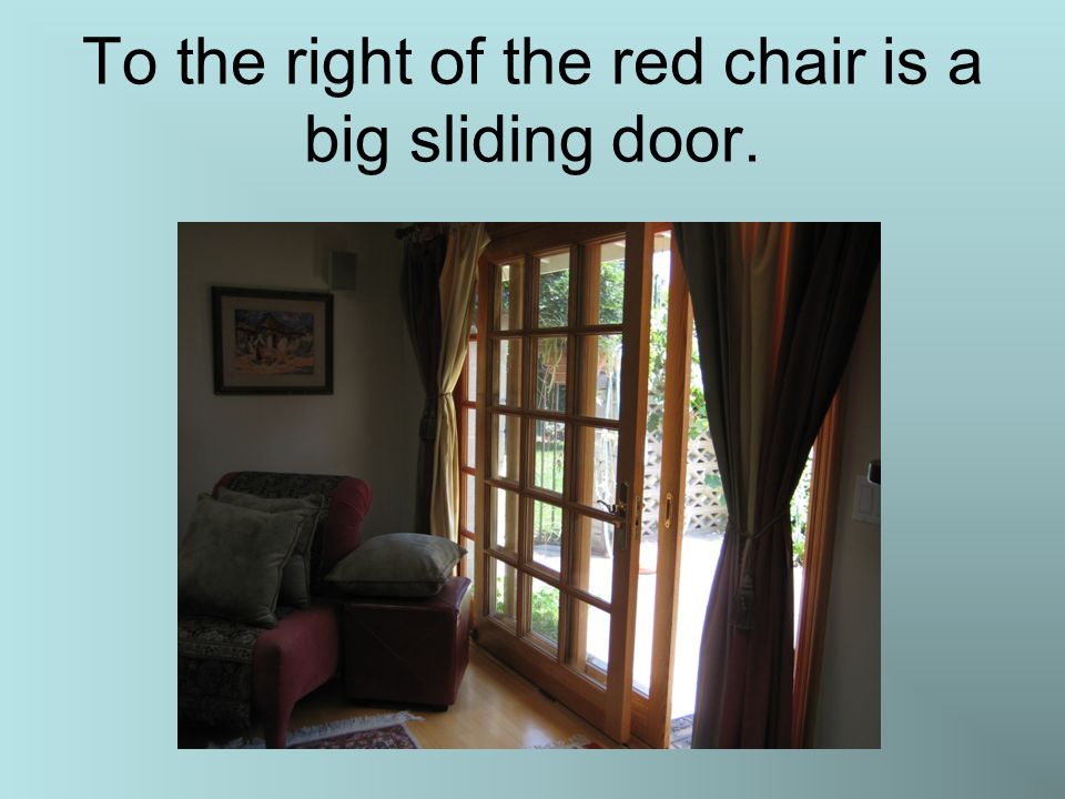To the right of the red chair is a big sliding door.