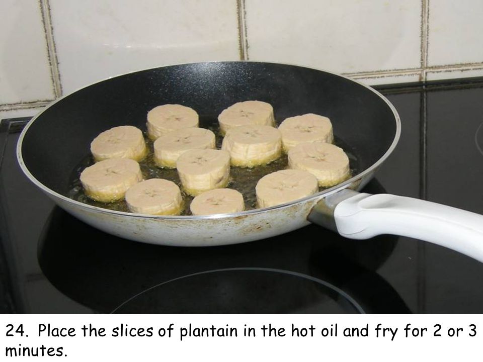 24. Place the slices of plantain in the hot oil and fry for 2 or 3 minutes.