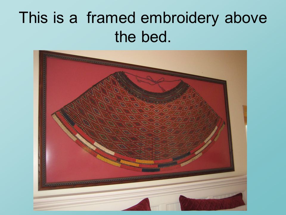 This is a framed embroidery above the bed.