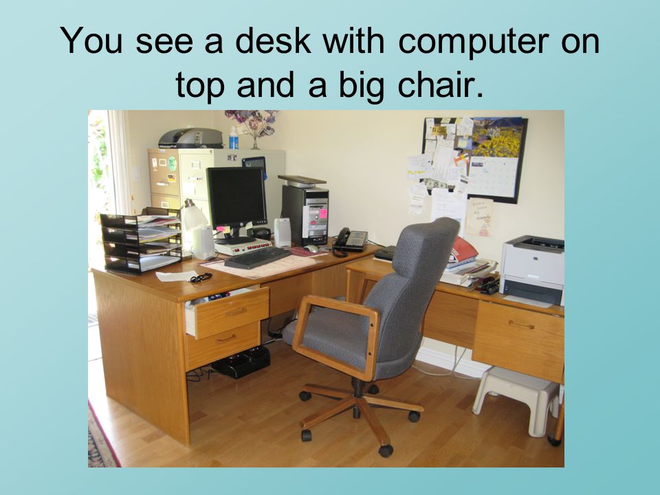 You see a desk with computer on top and a big chair.