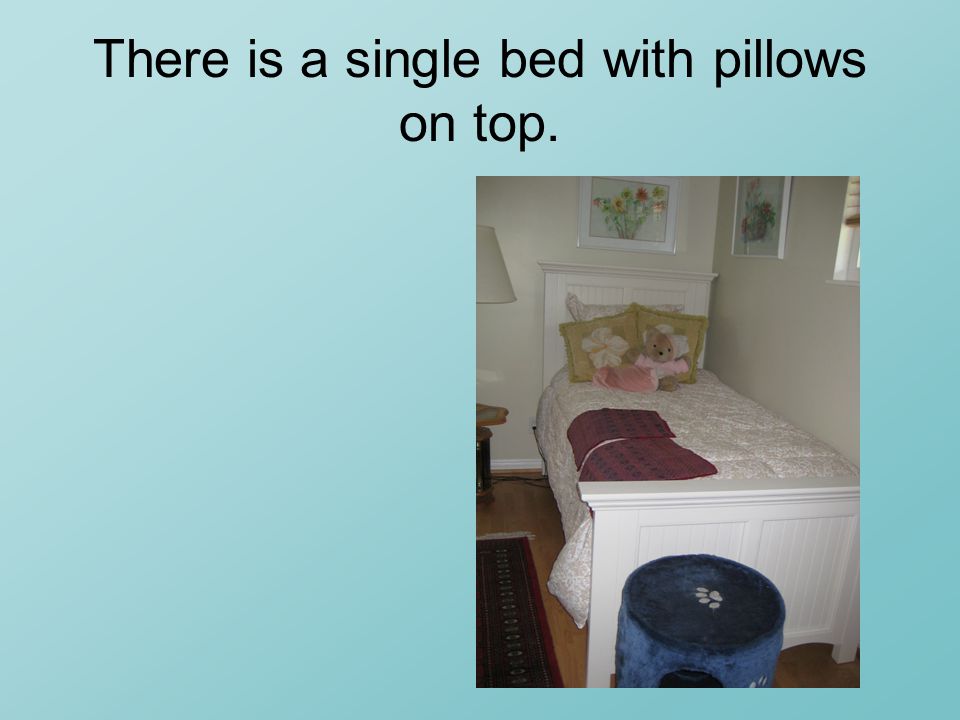 There is a single bed with pillows on top.