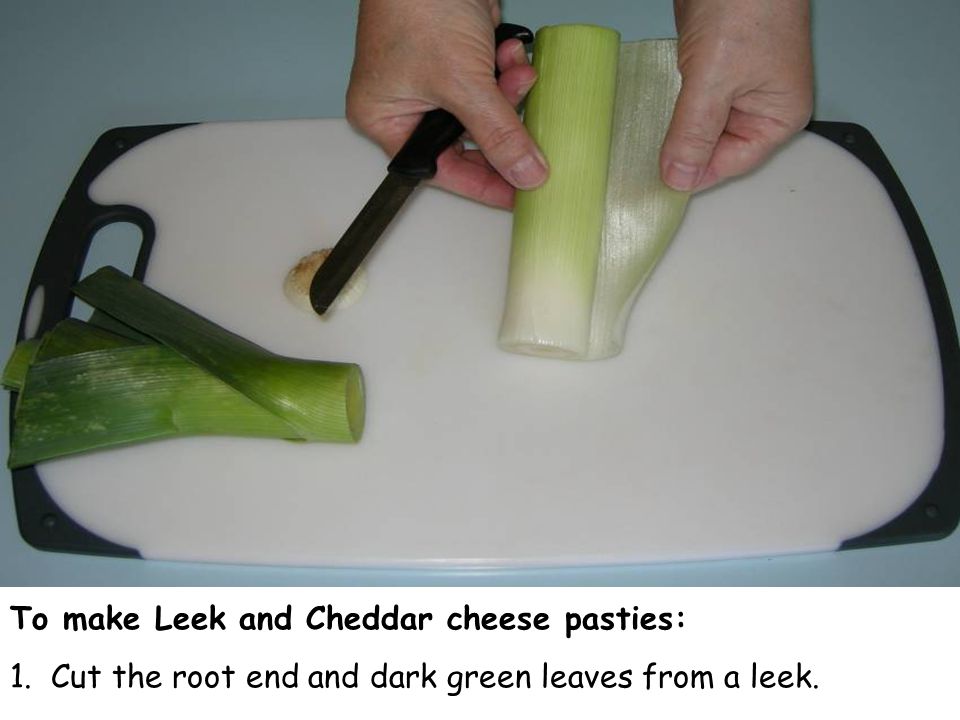 To make Leek and Cheddar cheese pasties: 1. Cut the root end and dark green leaves from a leek.