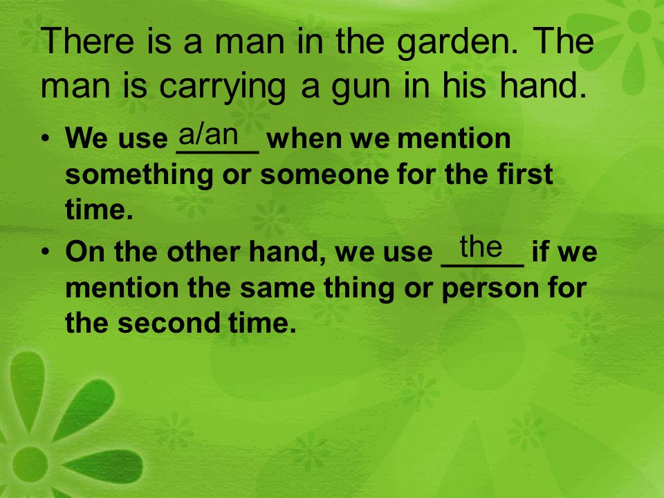 There is a man in the garden. The man is carrying a gun in his hand.