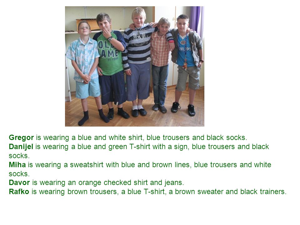 Gregor is wearing a blue and white shirt, blue trousers and black socks.