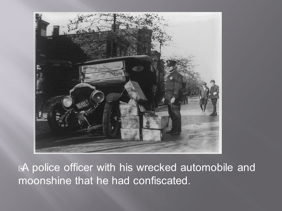  A police officer with his wrecked automobile and moonshine that he had confiscated.