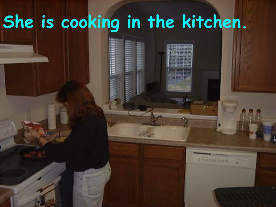What is mother doing She is cooking in the kitchen.