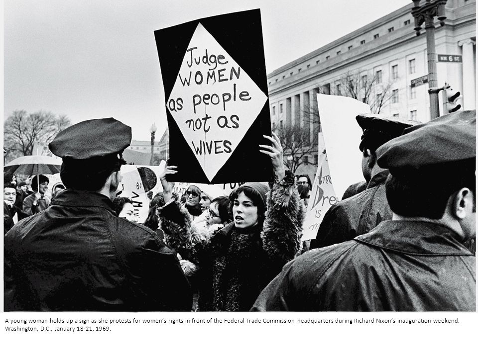 A young woman holds up a sign as she protests for women’s rights in front of the Federal Trade Commission headquarters during Richard Nixon’s inauguration weekend.