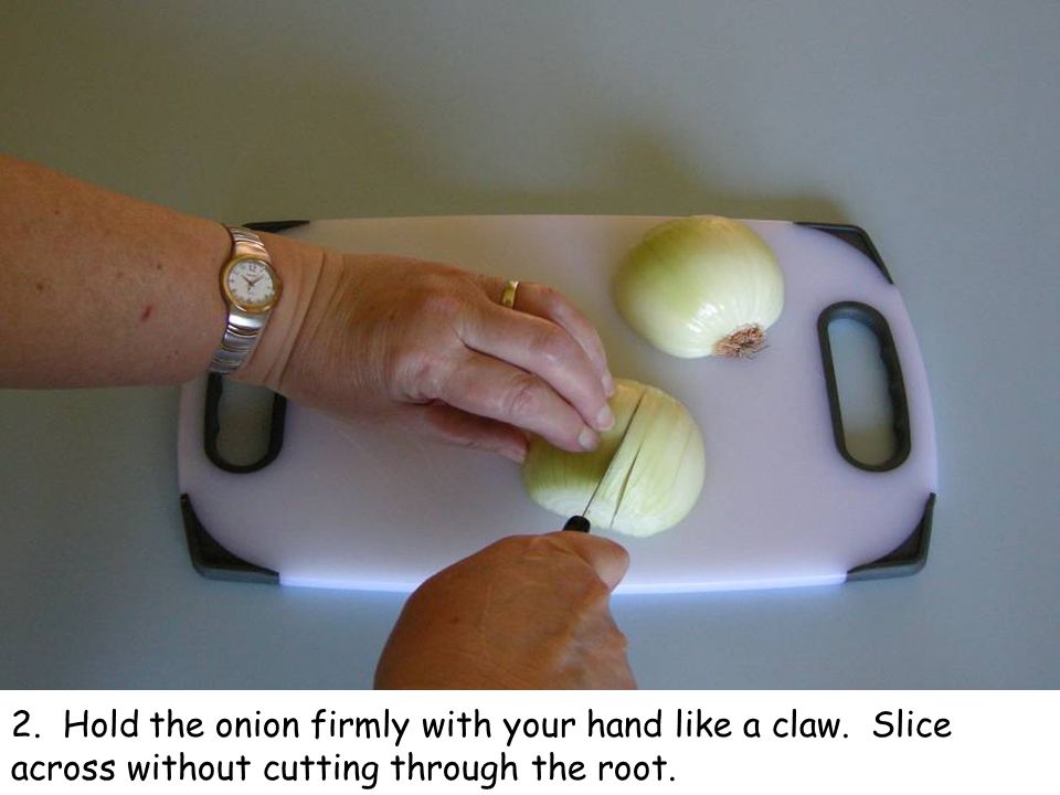 2. Hold the onion firmly with your hand like a claw. Slice across without cutting through the root.
