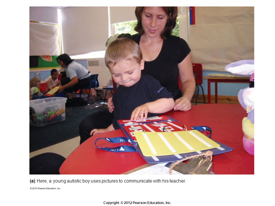 (a) Here, a young autistic boy uses pictures to communicate with his teacher.