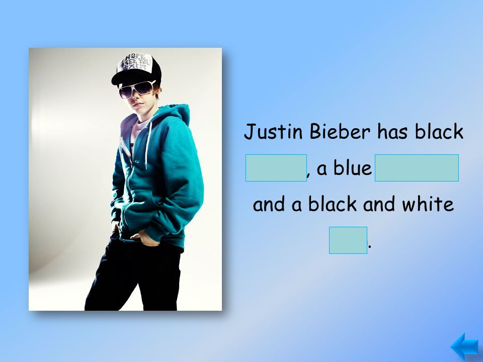 pantssweater cap Justin Bieber has black pants, a blue sweater and a black and white cap.