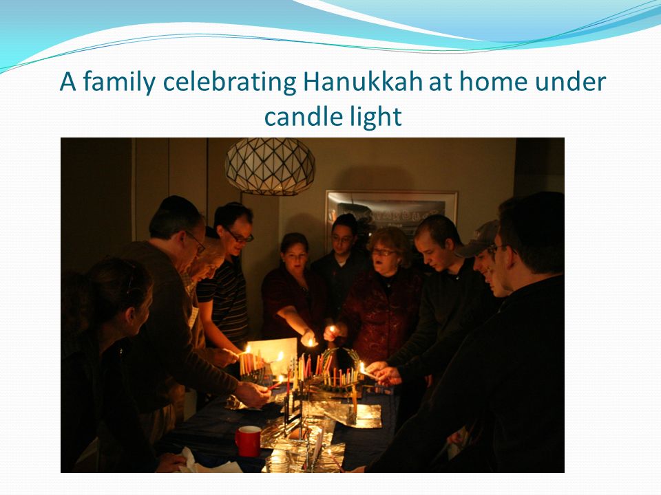 A family celebrating Hanukkah at home under candle light